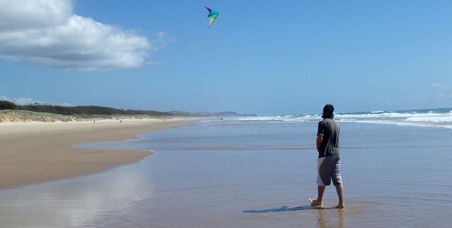 Man flying kite on beach
